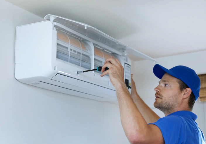 worker installing new air conditioning system unit inside the house